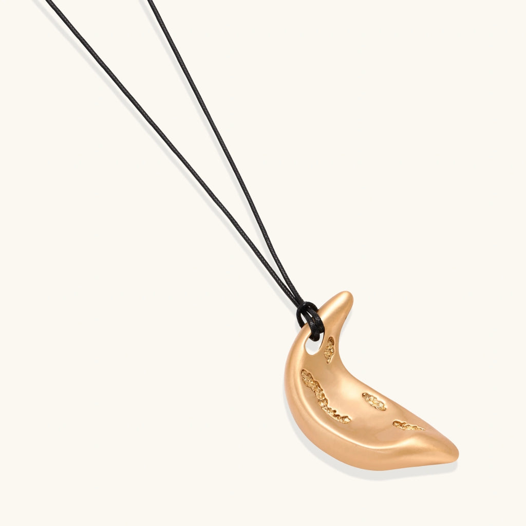Adjustable crescent moon pendant necklace in gold and silver eco-zinc alloy with decorative engravings on black cord