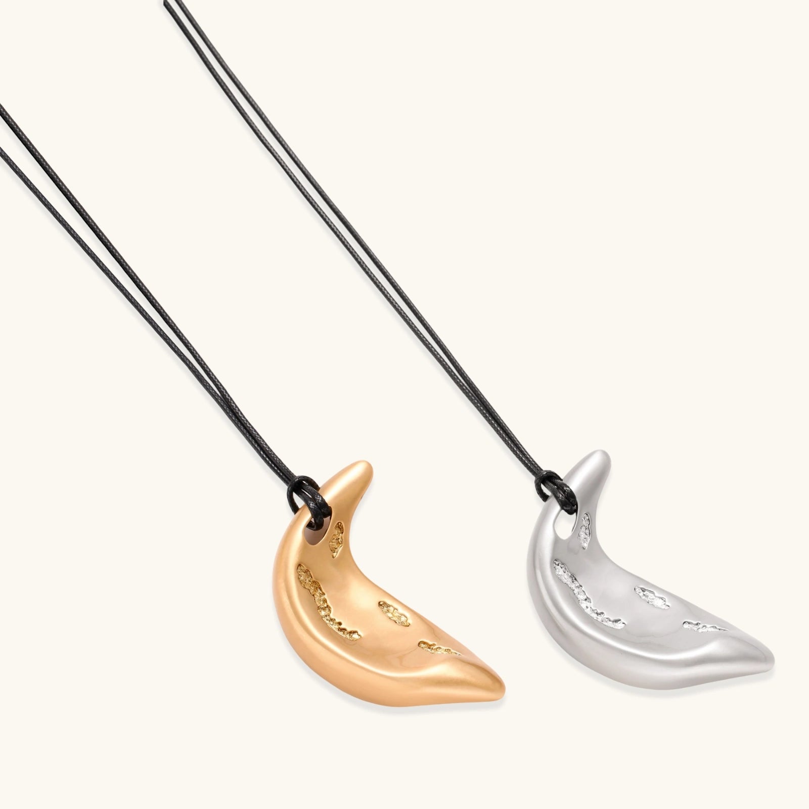 Adjustable crescent moon pendant necklace in gold and silver eco-zinc alloy with decorative engravings on black cord